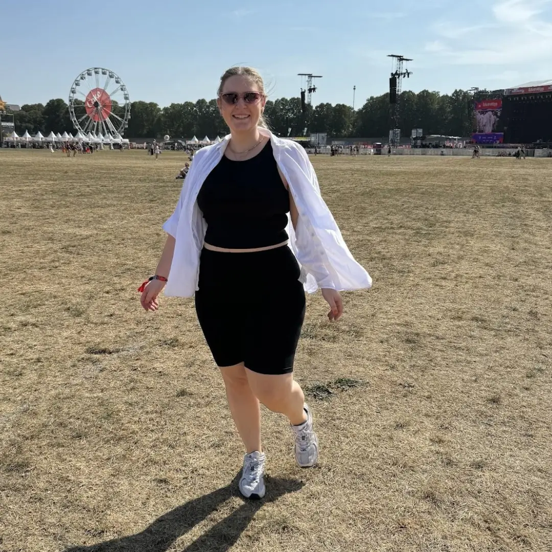 Lipödem-Patientin vor ihrer Operation – spaziert im Sommer auf einem Festivalgelände, sichtbar Bewegungseinschränkungen an den Beinen