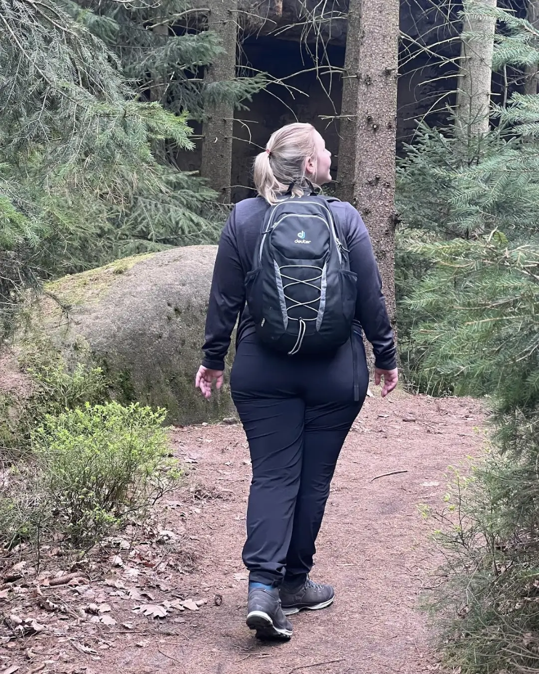 Frau mit Lipödem vor der Operation beim Wandern im Wald, von hinten fotografiert – Bewegung trotz Schmerzen